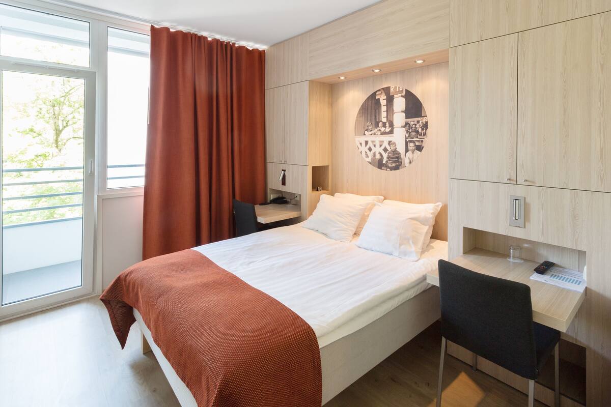 A modern bedroom with a bed, desk, and chair.