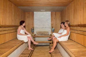 Een sauna met houten banken en een centrale tafel.