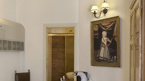 Une pièce comprenant un bureau en bois, une chaise, un canapé, un tableau et une armoire.