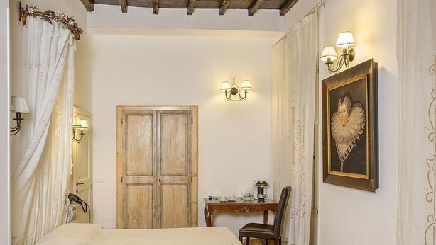 Une chambre à coucher avec un plafond en bois, un lit, un bureau avec une chaise, un tableau et une porte.