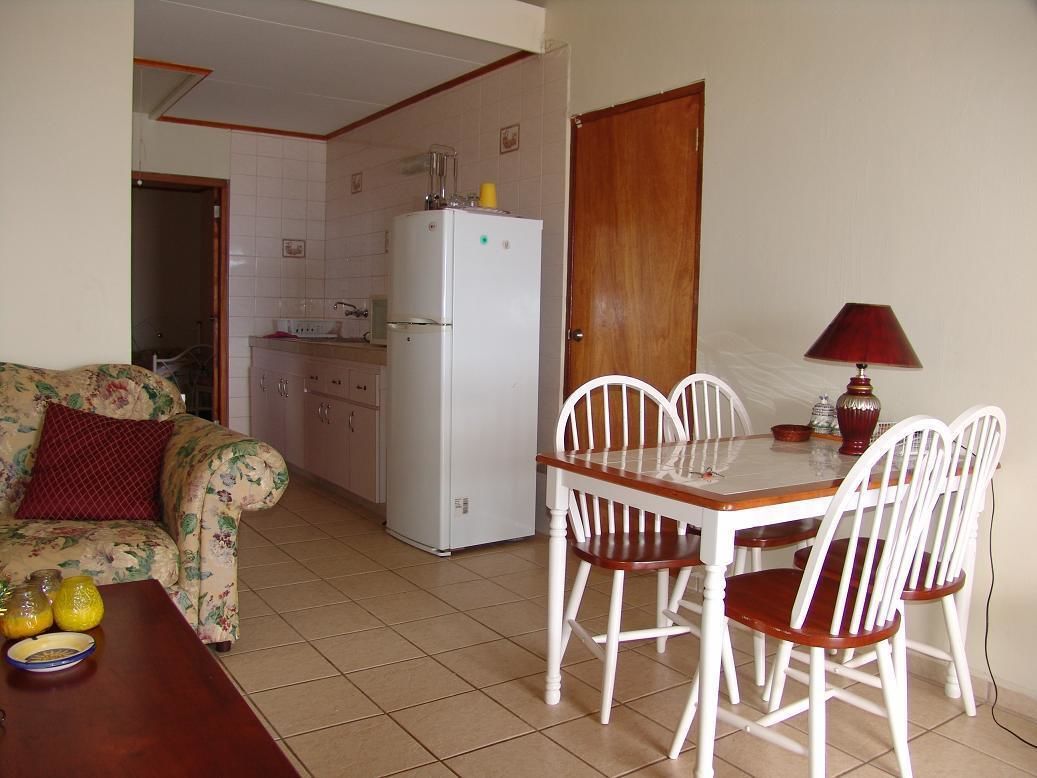 A compact living space with a dining area, a kitchenette, and a sofa.