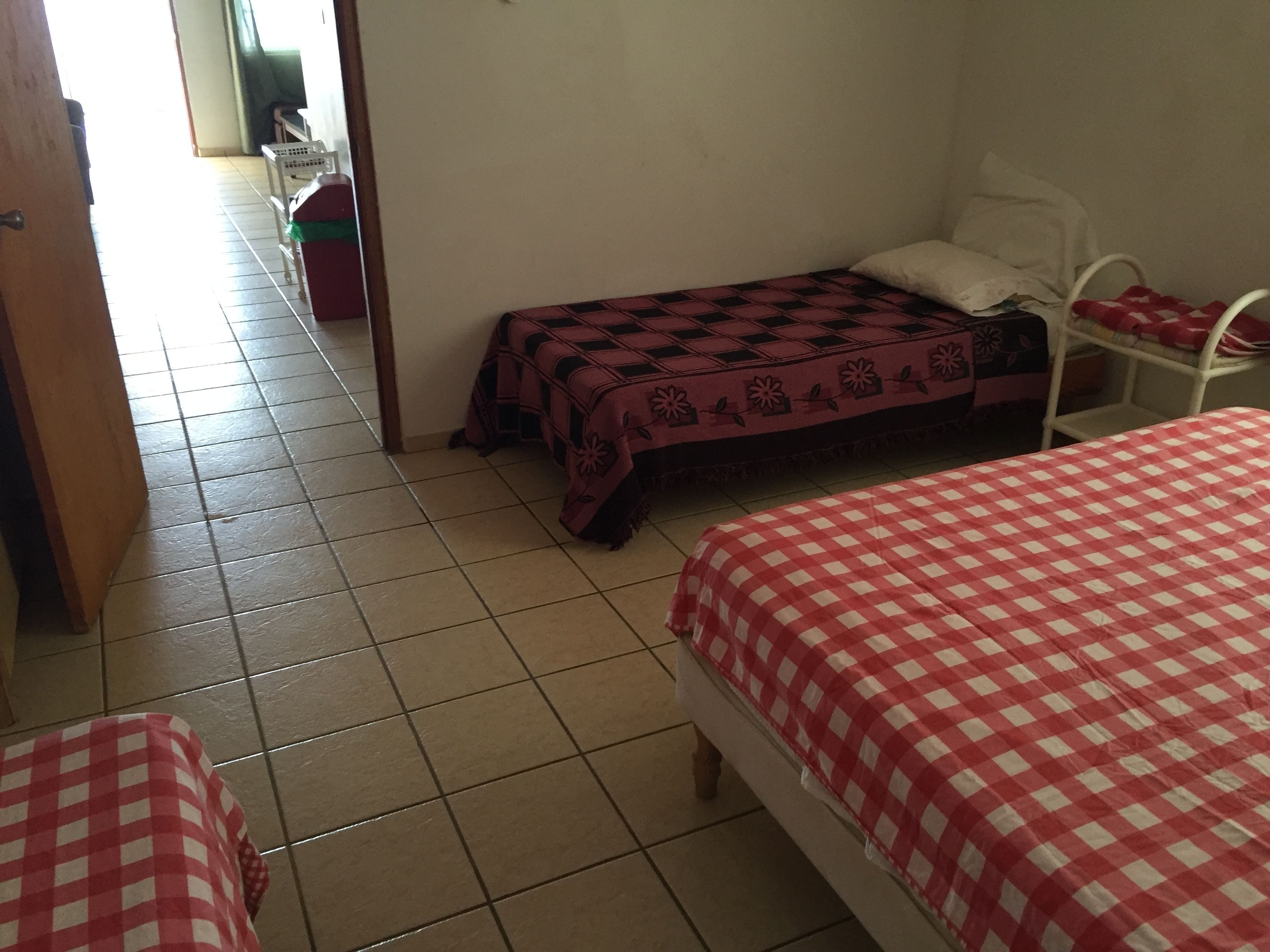 Una stanza con due letti, un tavolino e una sedia.