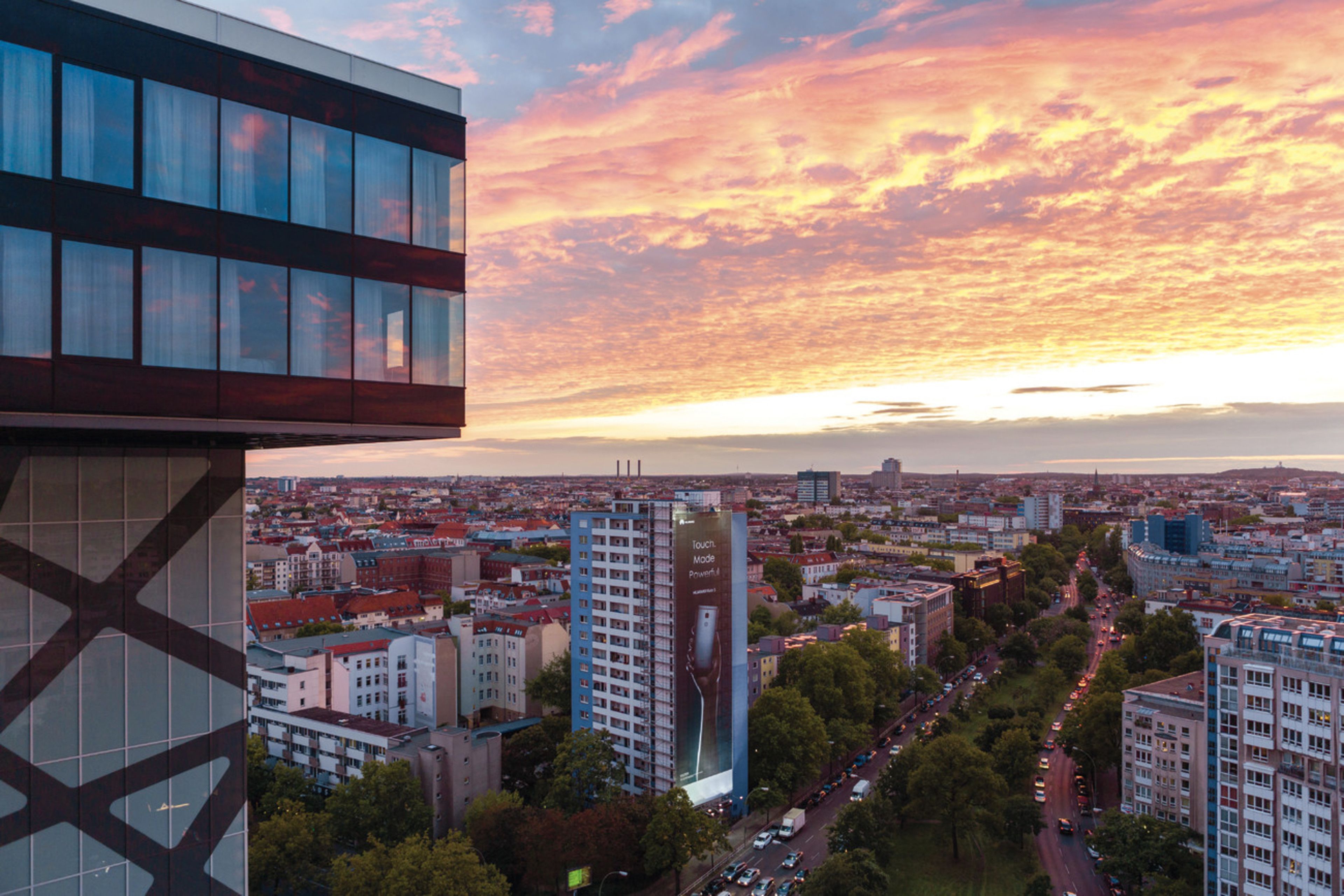 Un paisaje urbano con un edificio moderno destacado, que presenta un anuncio publicitario grande.