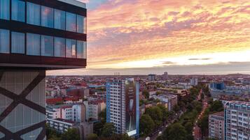 Un paisaje urbano con un edificio moderno destacado, que presenta un anuncio publicitario grande.