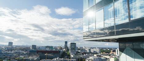 Un edificio moderno con amplios ventanales que reflejan el cielo y las nubes.