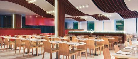 Un restaurante espacioso con varias mesas y sillas, que destaca por su moderno diseño de techo y amplios ventanales.