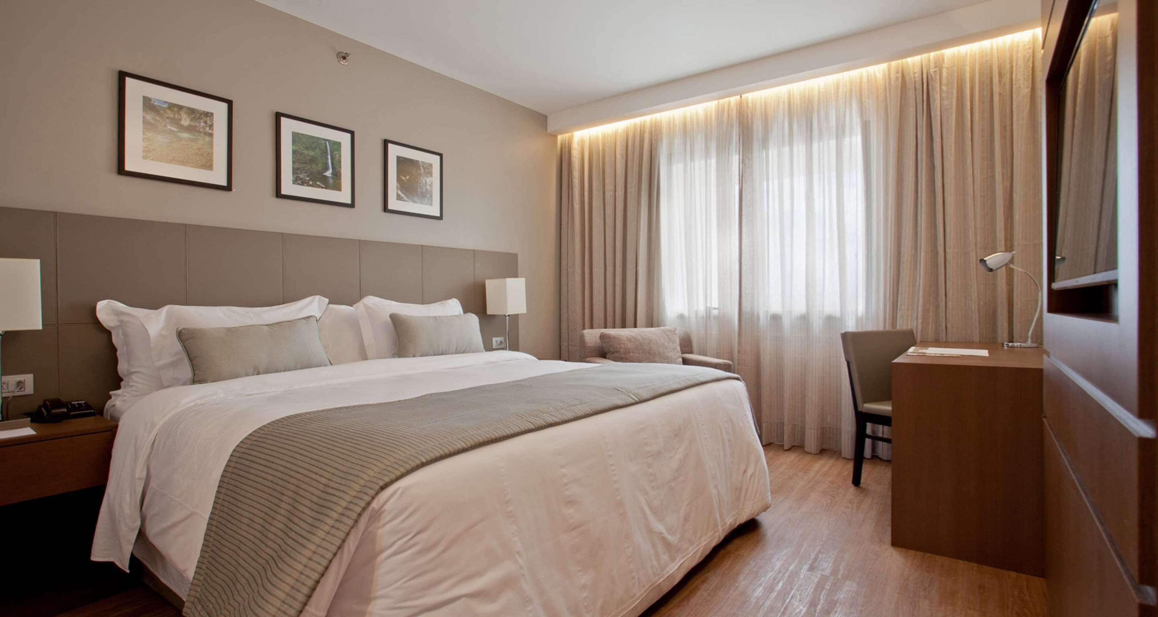 Habitación Deluxe, 1 cama de matrimonio grande | Minibar, caja fuerte, escritorio y cortinas opacas