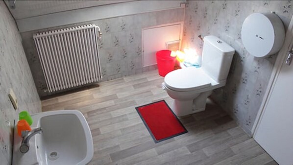 Un bany petit amb vàter, rentapel i radiador.