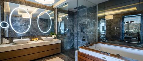 A modern bathroom with a large mirror, two sinks, a bathtub, and a glass shower enclosure.