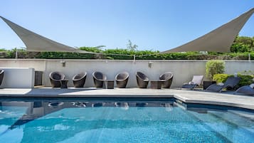 Una piscina al aire libre de temporada, tumbonas