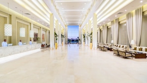 A spacious hotel lobby with a marble reception desk, seating area, and a view of the pool in the background. - JAZ Aquaviva - All inclusive (Makadi Bay)