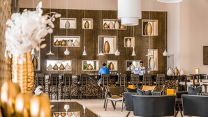A modern interior with a bar area, seating, and decorative vases. - JAZ Aquaviva - All inclusive (Makadi Bay)