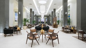 A spacious lobby with a central seating area, large pillars, and a modern ceiling design. - JAZ Aquaviva - All inclusive (Makadi Bay)
