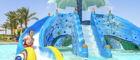 Un parque acuático con un tobogán azul grande y atracciones acuáticas.