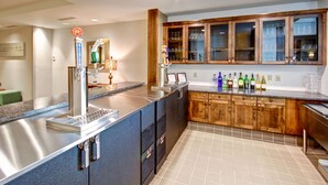 Una cucina moderna con isola in acciaio inox, mobili in legno e diversi elettrodomestici.