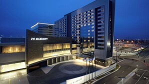 Un hotel JW Marriott con diseño moderno, que cuenta con una entrada destacada y un amplio estacionamiento.