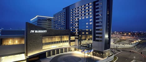 A JW Marriott hotel with a modern design, featuring a prominent entrance and a large parking area.