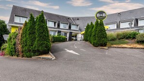Un hotel B&B de diseño moderno, con techo curvo y entrada central.