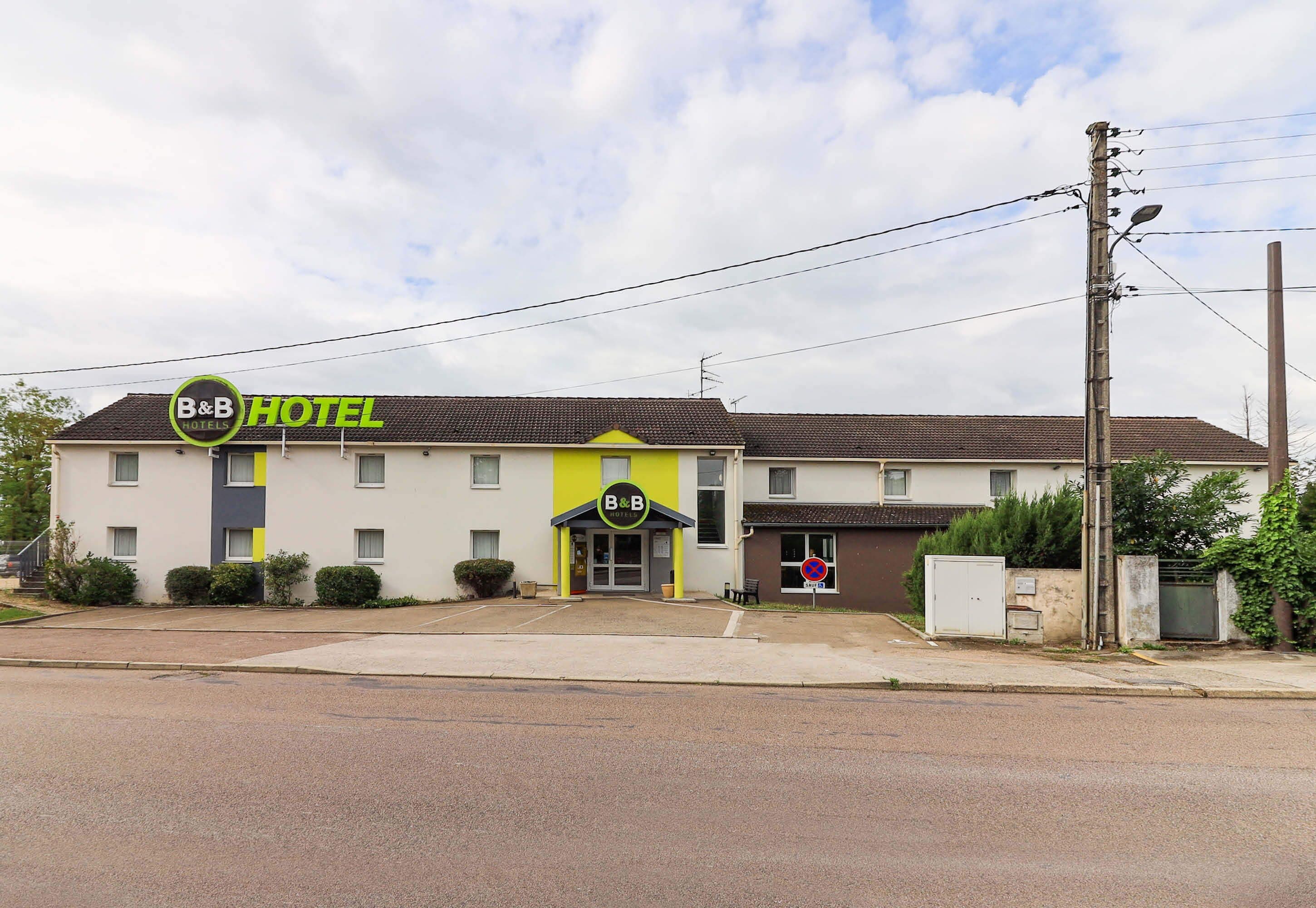 A B&B hotel with a simple facade, a front entrance, and a parking area.