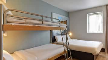 A room with two bunk beds, a ladder, a window with curtains, and a wall-mounted light fixture.
