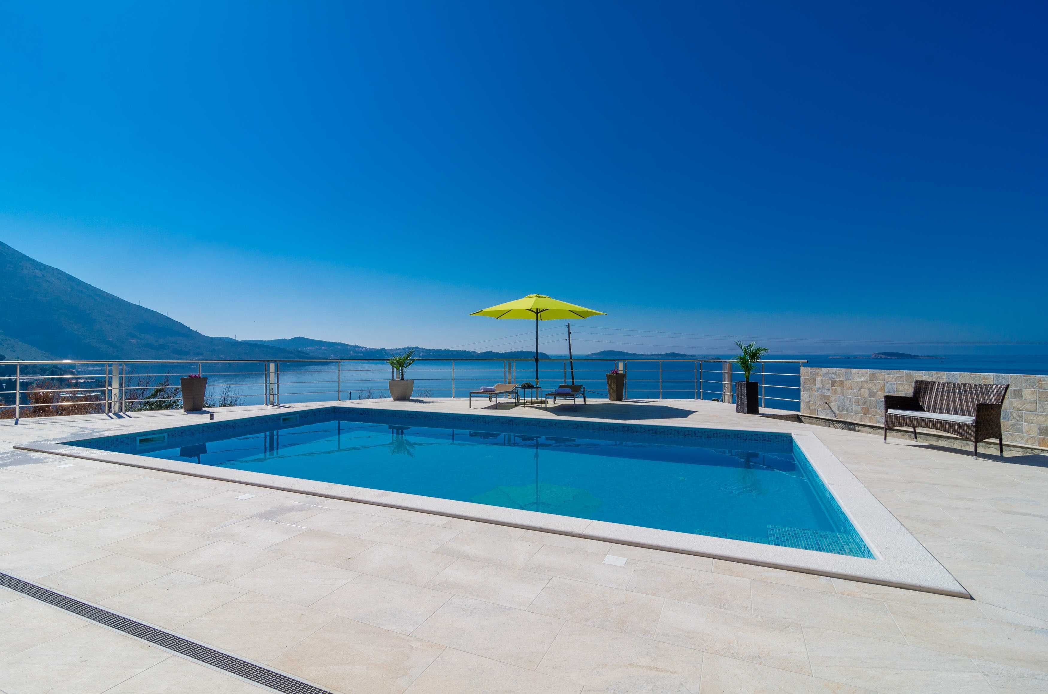 Een seizoensgebonden buitenzwembad en ligstoelen