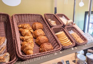 Wicker baskets filled with various breads and pastries on display. - B&B HOTEL Limoges (1) (Limoges)