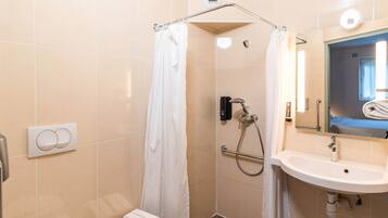 A modern bathroom with a shower, toilet, and sink.