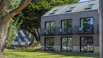 Un bâtiment moderne à deux étages, doté d’un toit plat, de grandes fenêtres et d’un balcon.