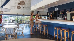 A bar area with wicker furniture, a counter, and a view of the outdoors. - Belambra Clubs Guidel - Les Portes De L'Océan (Guidel)