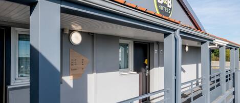 A B&B hotel with a modern design, featuring a signboard, a clock, and a small window.