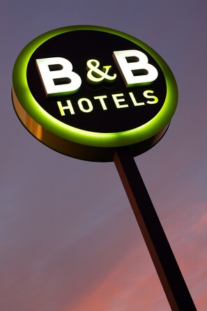 A circular sign with the text "B&B HOTELS" against a purple sky. - B-B Hotel Nantes Parc Expos LA Beau (Nantes)