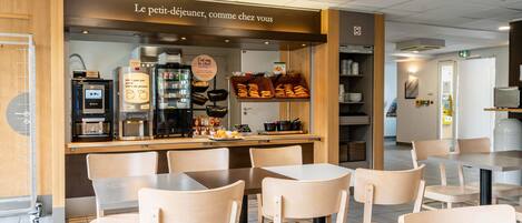 A café with a wooden counter, seating area, and coffee machines.