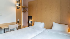 A hotel room with a wooden headboard, a desk with a chair, and a bed with white bedding. - B&B HOTEL Aix-en-Provence Le Tholonet (Le Tholonet)