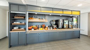 Una cocina americana moderna con armarios grises, encimera de madera y varios electrodomésticos y utensilios de cocina.
