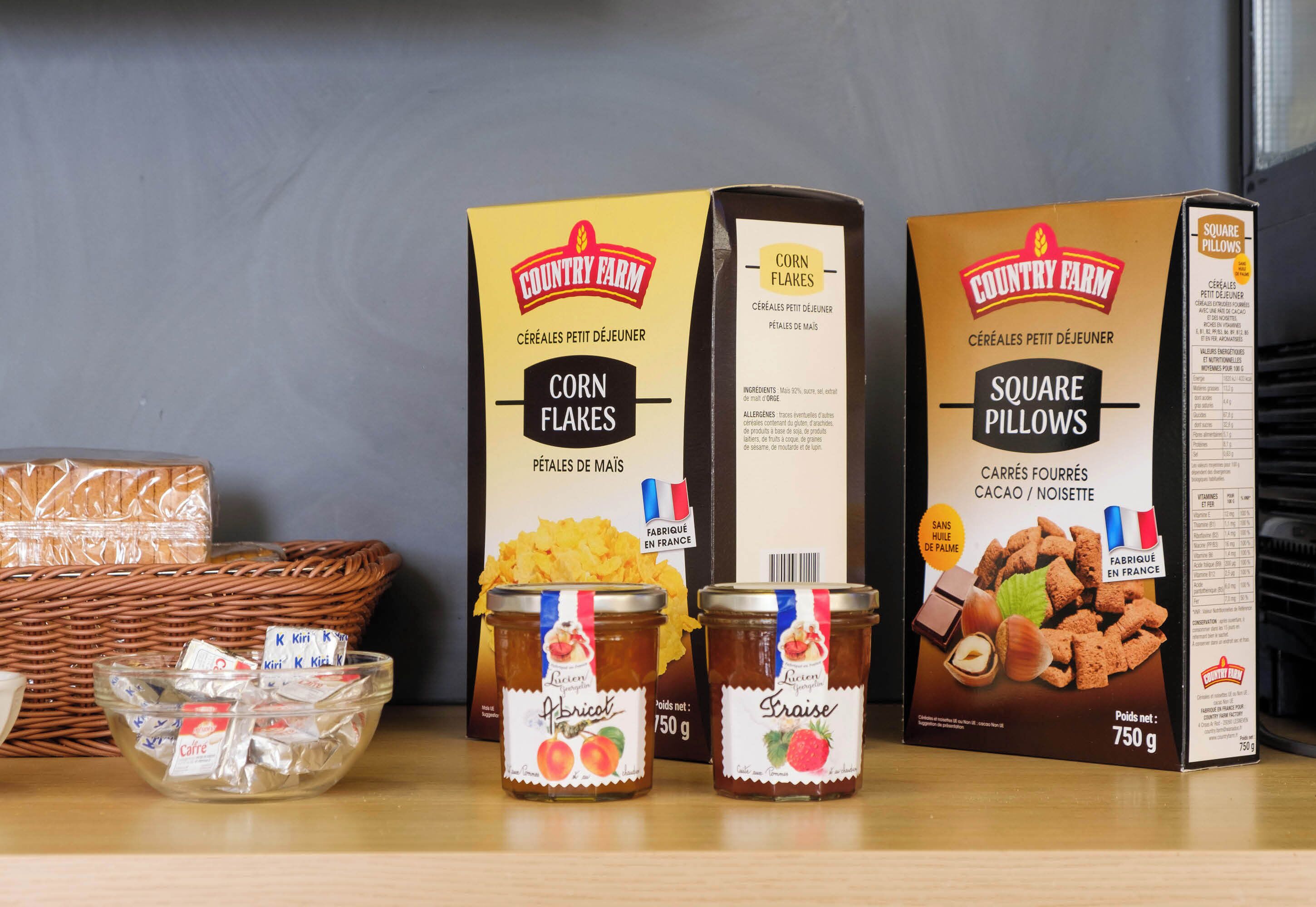 Cajas de cereales, frascos de conservas y una cesta de mimbre en un estante.