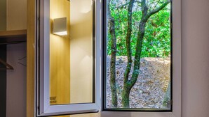 Una ventana que da a vista de árboles y una estructura de madera.