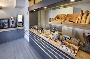 Una barra de desayuno con diferentes alimentos y una máquina de café.