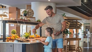 Un hombre y un niño en un bufé con una variedad de frutas y un letrero que dice "Dessert Signature".