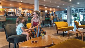 Un moderno bar con asientos, barra y vistas al exterior.