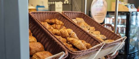 Una vitrina de panadería con cestas de cruasanes y otras delicias horneadas.