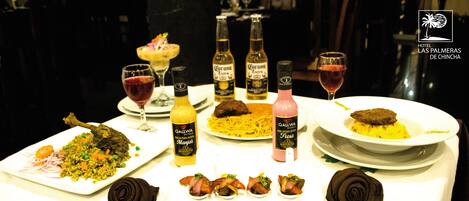 A dining table with various dishes, drinks, and a Qallwa Hotels logo.