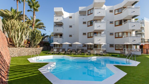 A modern hotel with a pool, multiple balconies, and palm trees. - Apartamentos Datasol (San Bartolomé de Tirajana)