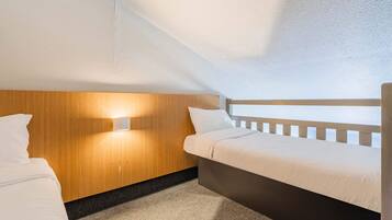 A small, cozy room with a bunk bed, a wooden headboard, and a wall-mounted light fixture.