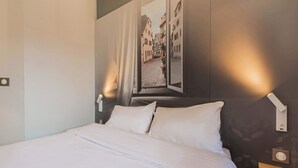 A neatly made bed with white linens in a hotel room. - B&B HOTEL Strasbourg Sud Ostwald (Ostwald)