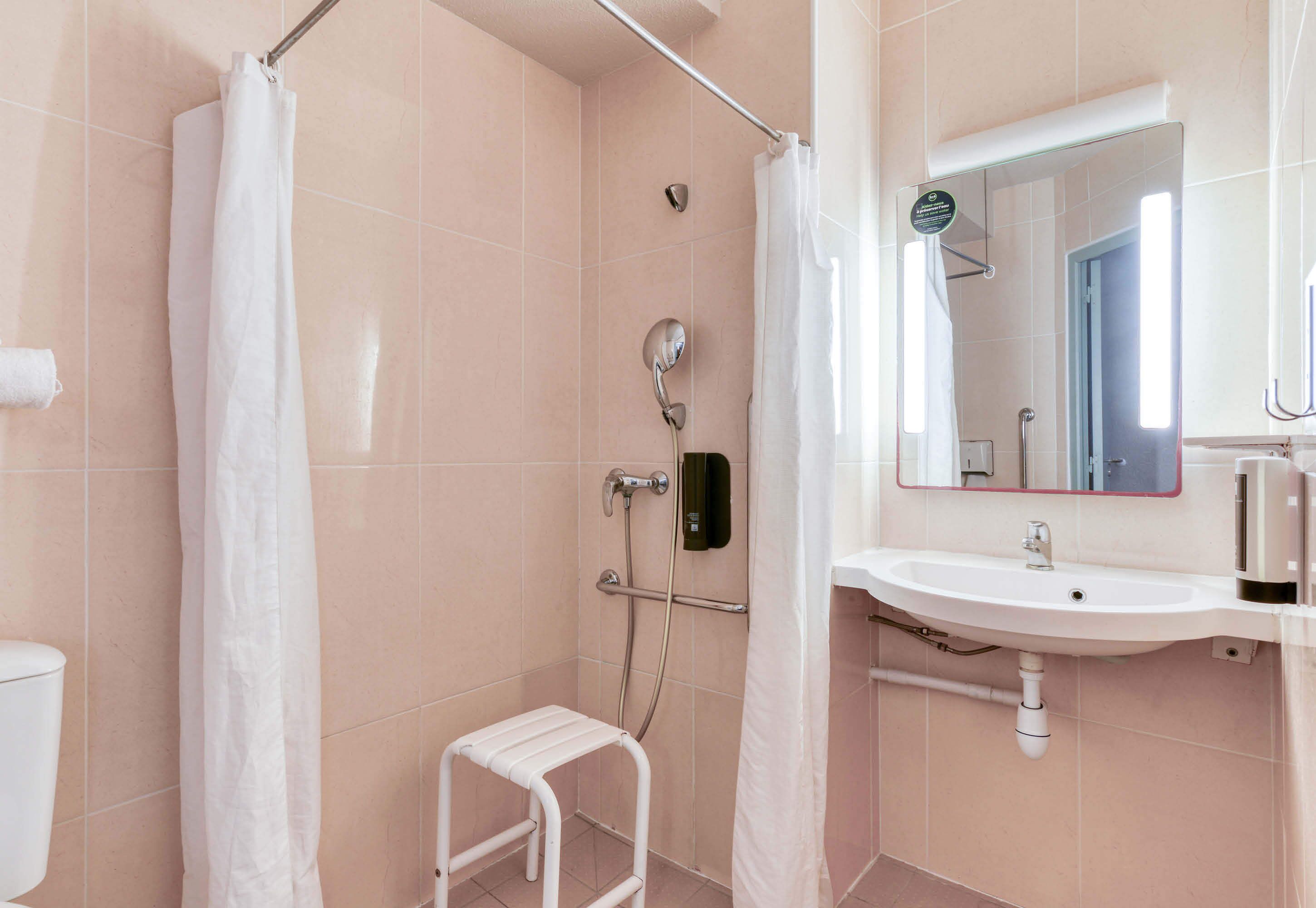 A bathroom with a shower, toilet, and sink.