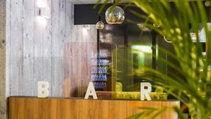 A reception desk with a wooden finish and letters spelling "BAR" on top. - B&B HOTEL Paris Malakoff Parc des Expositions (Malakoff)