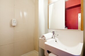 A bathroom with a white sink, a mirror, and a hand dryer on the wall. - B&B Hotel Valenciennes Marly (Marly)