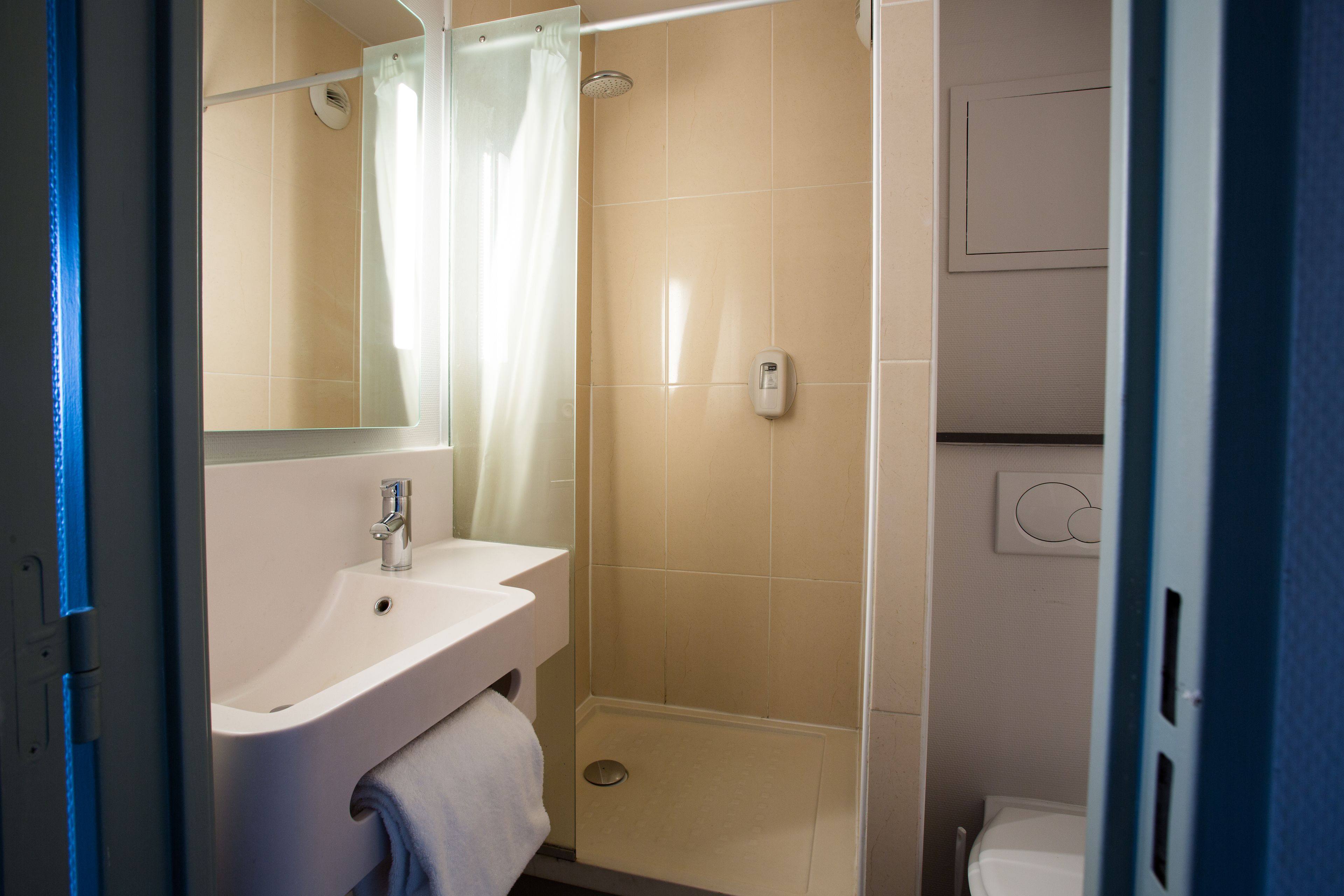 A bathroom with a sink, mirror, shower, and toilet.