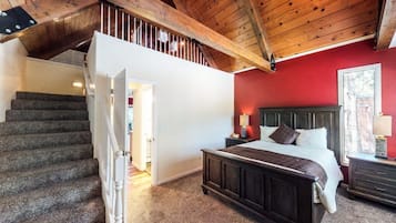 Une chambre à coucher comprenant un lit, une table de chevet et un escalier menant à un niveau supérieur.