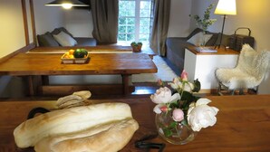 A dining area with a wooden table, benches, and a vase with flowers. - Residencia Pioneros (San Carlos de Bariloche)